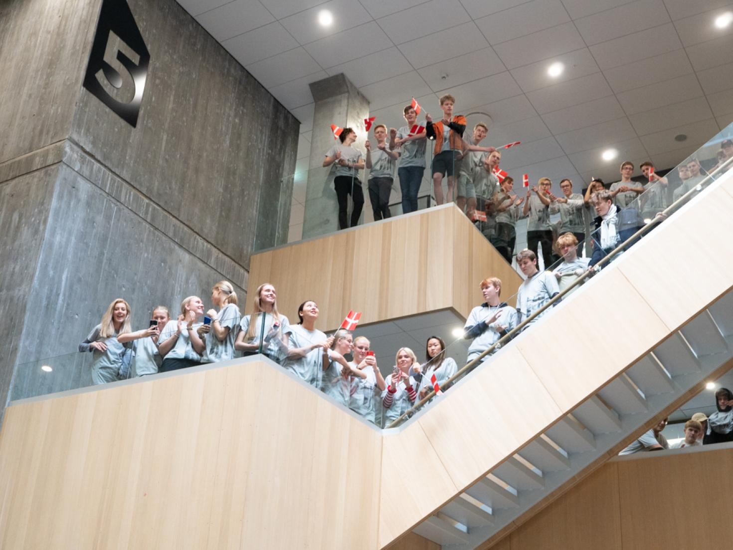 Fest i hallen på Midtbyens Gymnasium unge med flag 