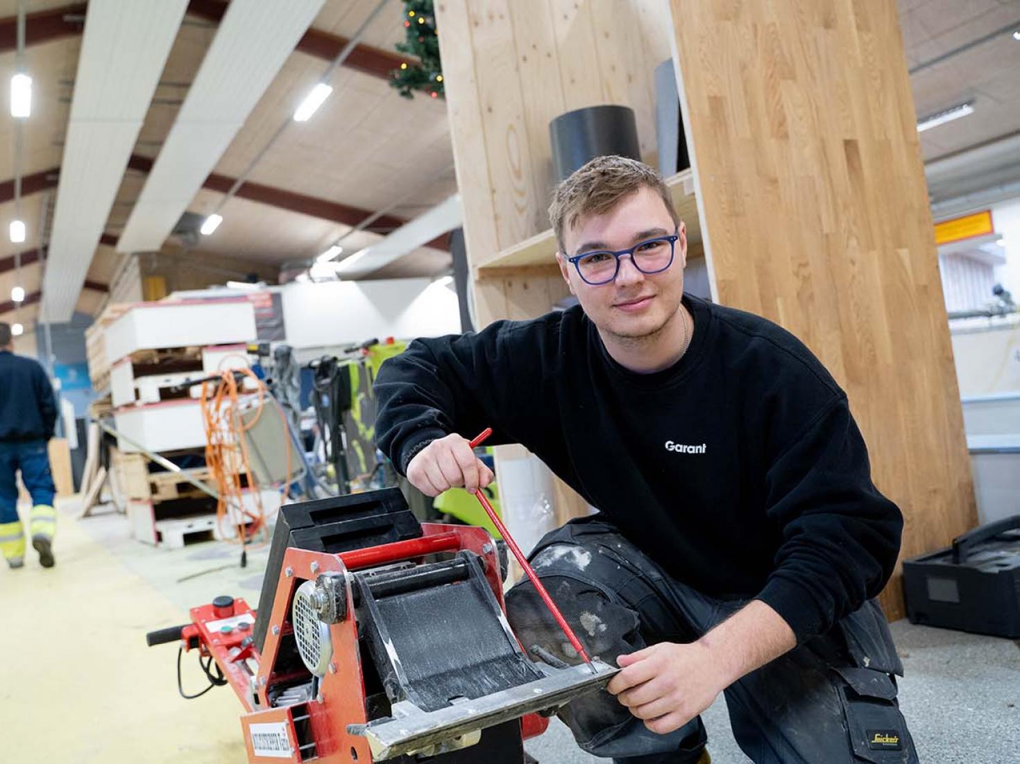 Elev med maskine på gulvlæggeruddannelsen