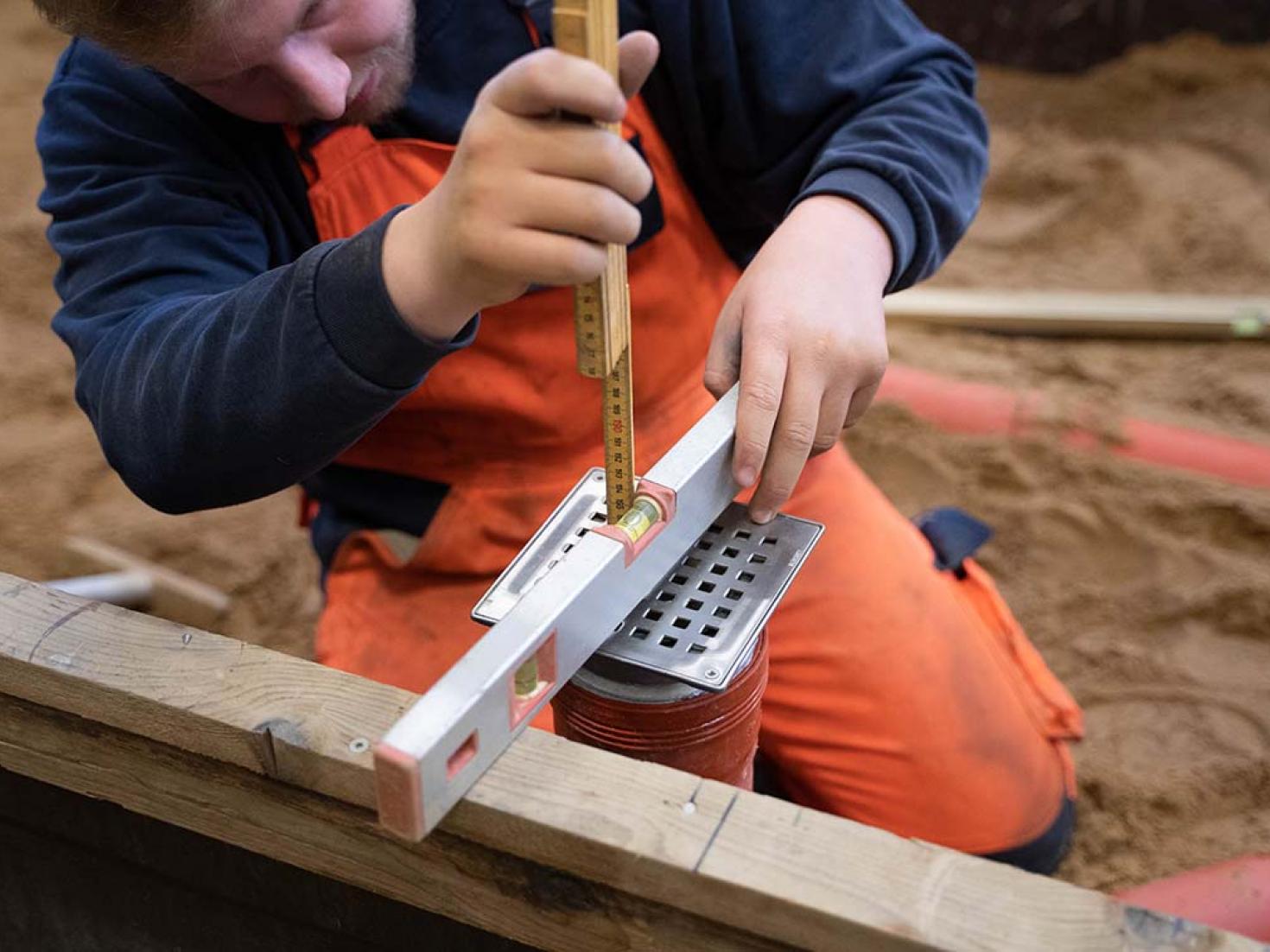 struktør arbejder med rør i sandgrav