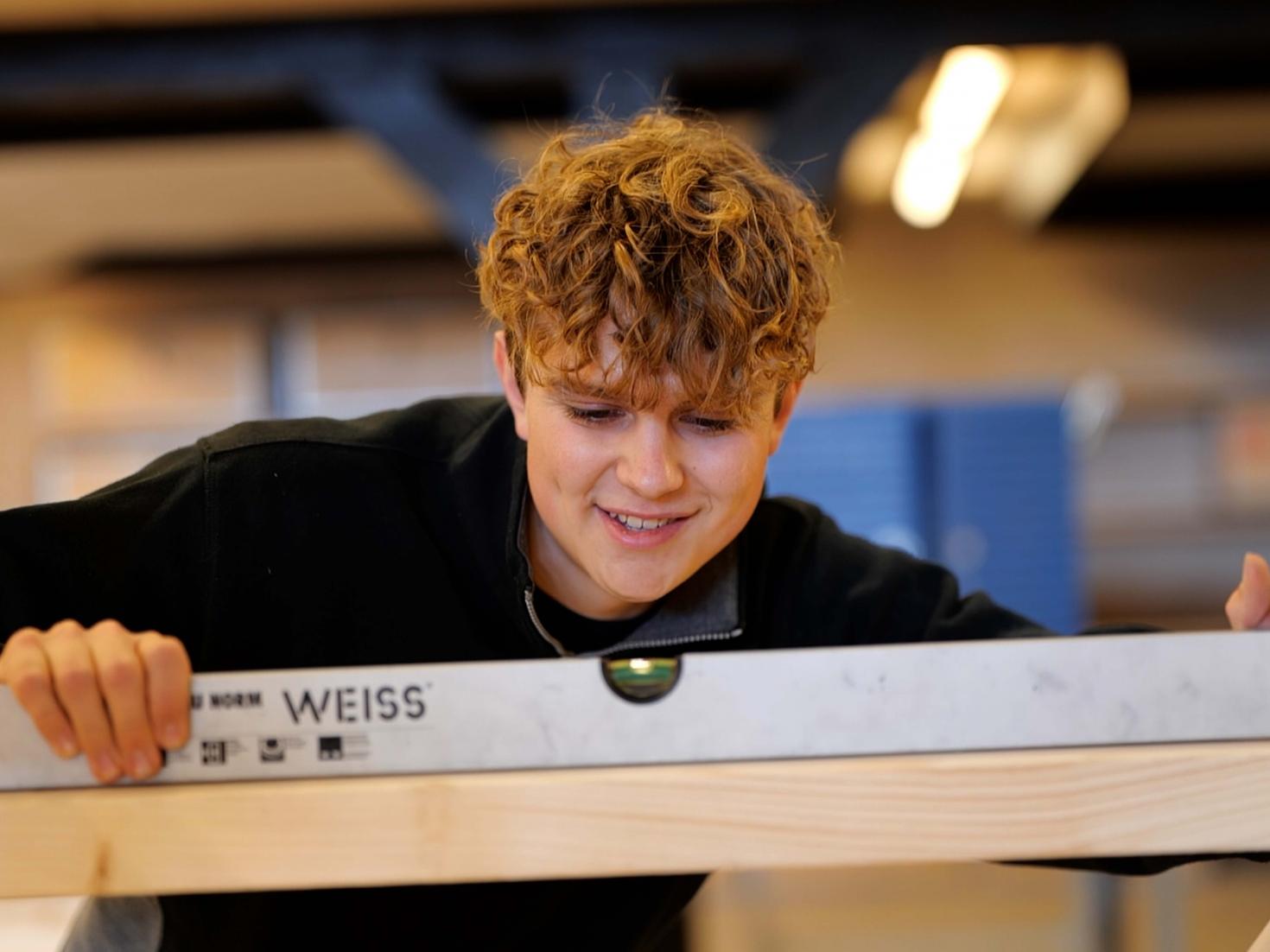 Elev tømrer arbejder med træ